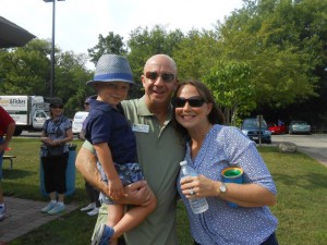 Charles McLimans and Megan Selck pose together with Megan's son, Drew, at the Volunteer Picnic